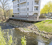Ufersanierung Lohrstraße Chemnitz, Ufer unterhalb Wohnhaus mit großen Steinen befestigt