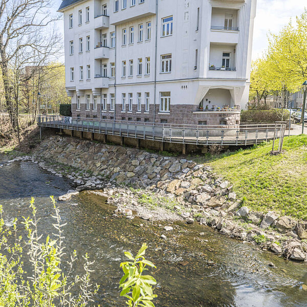Ufersanierung Lohrstraße Chemnitz, Ufer unterhalb Wohnhaus mit großen Steinen befestigt