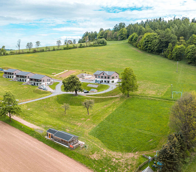 Seiffen Wellnessresort Erlebnisdorf, Drohnenaufnahme auf Hotelanlage am grünen Hang