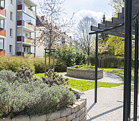 Wohnumfeld Comeniusstraße Chemnitz, Grünanlage mit Hochbeet und Pergola neben einem Wohnhaus,