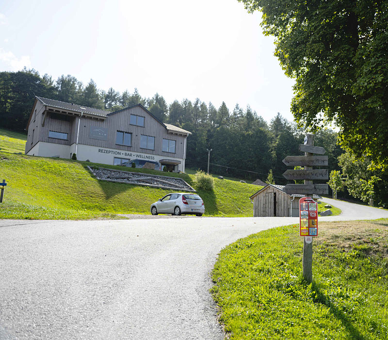 Seiffen Wellnessresort Erlebnisdorf, Auffahrt mit Wegweiser zum Hotel am Hang