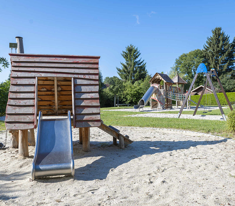 Spielplatz Köthensdorf, Spielhaus mit Rutsche, im Hintergrund Schaukel und Klettergerüst