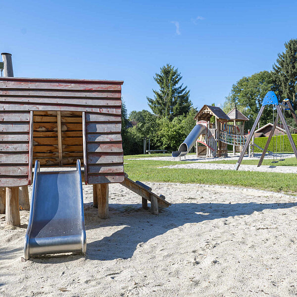 Spielplatz Köthensdorf, Spielhaus mit Rutsche, im Hintergrund Schaukel und Klettergerüst